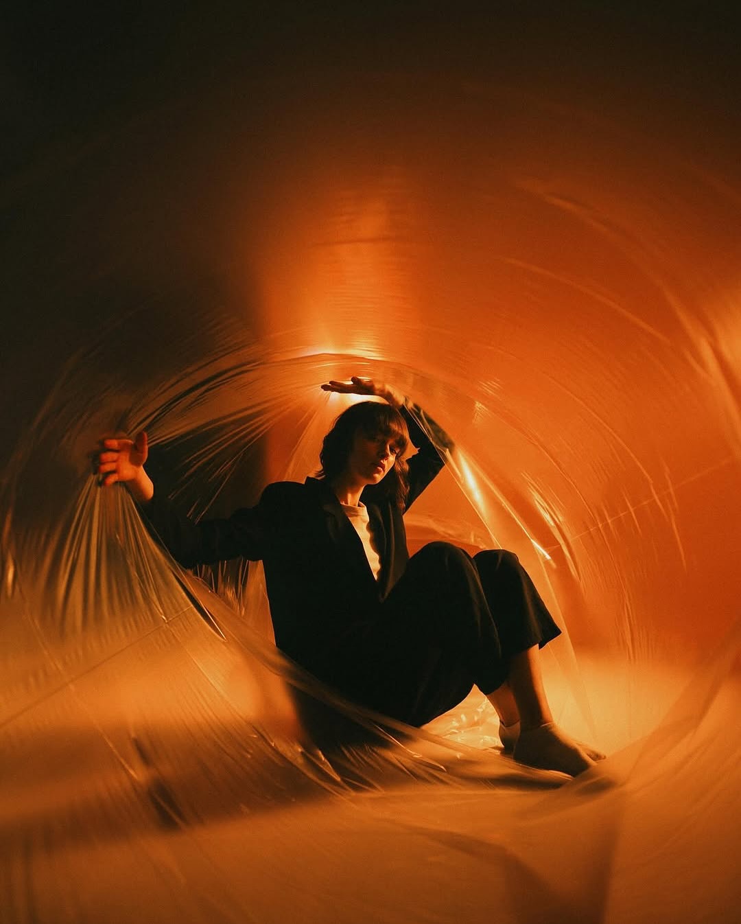 Portrait wrapped in translucent amber-lit material